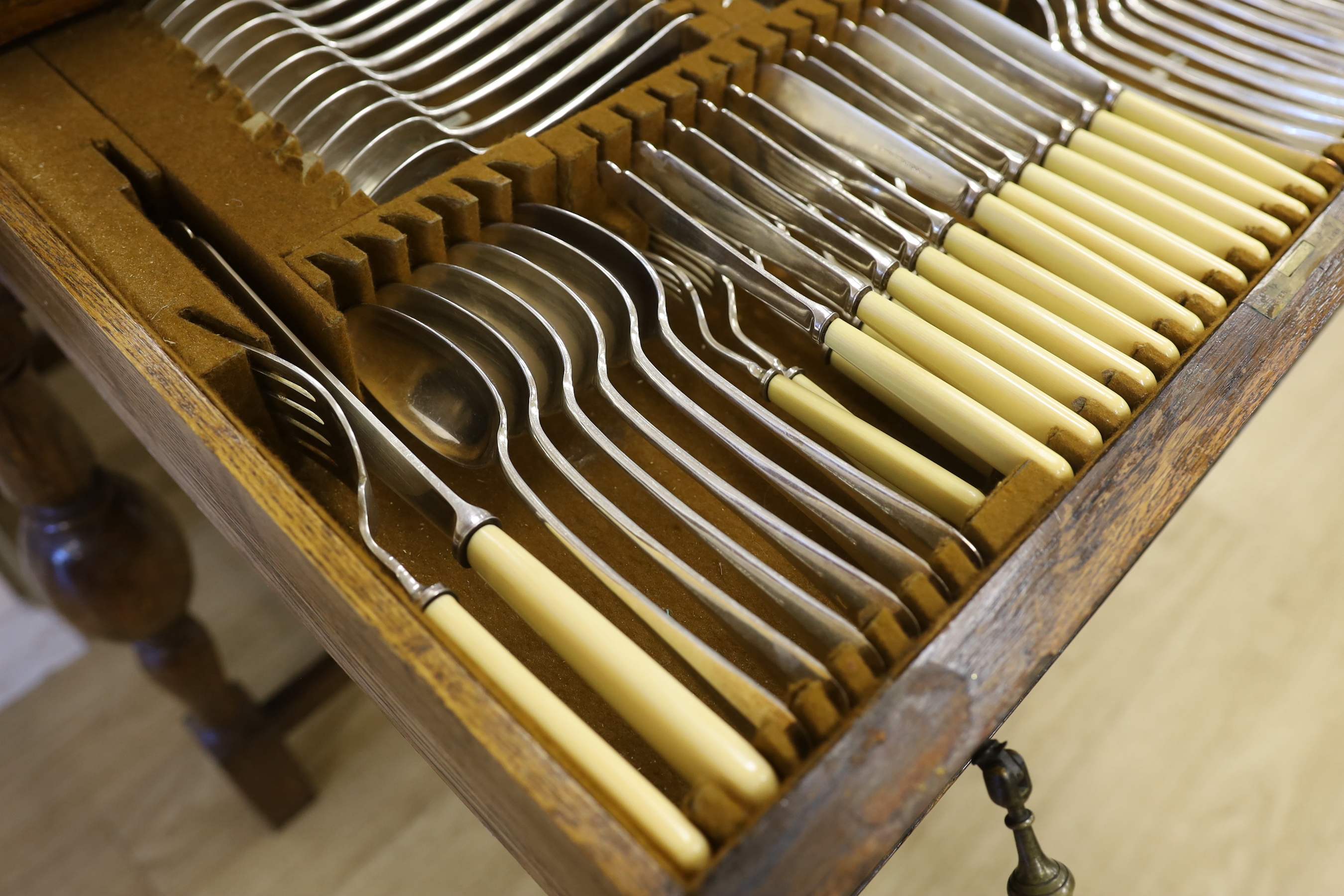 An oak standing canteen with two drawers of Mappin and Webb silver plated cutlery, settings for twelve people, 78cm high x 70cm wide x 54cm deep